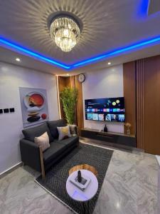 ラゴスにあるNike's Placeのソファとテレビのあるリビングルーム