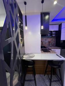 ラゴスにあるNike's Placeのキッチン(白いカウンター、バースツール2つ付)