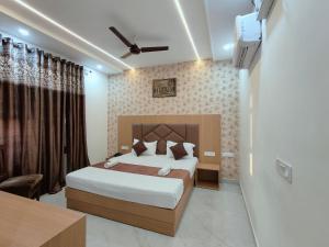 a bedroom with a large bed and a tv at Hotel Pilgrim Near Golden Temple in Amritsar