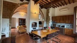 a kitchen with a wooden table and a living room at Agriturismo Podere Cortilla in Volterra