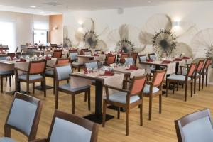 a dining room filled with tables and chairs at Domitys Le Millésime in Bordeaux