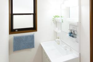 ein weißes Badezimmer mit Waschbecken und Spiegel in der Unterkunft 一棟貸 風kaze in Ōgaki + 21 Fotos