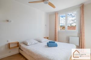 Bel appartement 3 pièces aux portes de Lyon في بيير - بينيت: غرفة نوم عليها سرير وفوط زرقاء