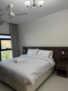 Qala View Inn في نزوى‎: غرفة نوم بها سرير أبيض كبير ونافذة +7 صور