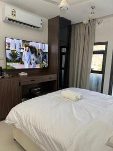 a bedroom with a bed and a flat screen tv at Qala View Inn in Nizwa +7 photos