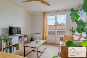 Bel appartement 3 pièces aux portes de Lyon في بيير - بينيت: غرفة معيشة مع أريكة وطاولة