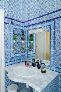Dar Ali - Comfort stay في توزر: حمام مع حوض والجدار الأزرق البلاط