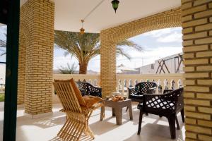 Dar Ali - Comfort stay في توزر: باحة فيها كراسي وطاولة والنخيل