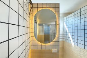 uno specchio sul muro di un bagno di Nana Best Hostel a Makkasan