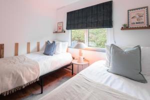 a bedroom with two beds and a window at Secluded Sanctuary On The River in Christchurch