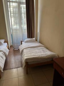 Un dormitorio con dos camas frente a una ventana. en Lucky Travelers Room, en Tiflis