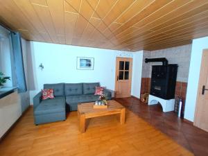 a living room with a couch and a coffee table at Gästehaus am Hofberg in Thalmässing +2 photos