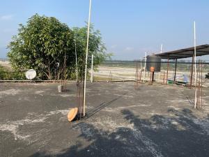 a basketball hoop in a parking lot with a tree at Rigerous Valley in Khairāni