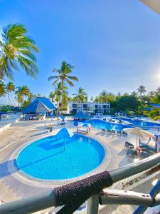 a large swimming pool with palm trees in a resort at Protels La Plage Resort in Bwejuu