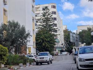 チュニスにあるHouse Y clinique Manar et Campusの高層ビルの前に停車する白いトラック +10枚の写真