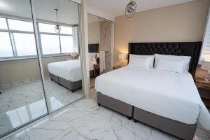 a bedroom with a large bed and a mirror at Modern Beach View in Kingsborough +1 photo