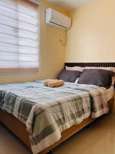 a bed with a stuffed animal laying on it at JOs HOMEtel at Heritage City of the South Carcar in Guinauayan