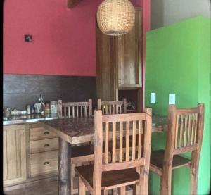 a kitchen with a wooden table and some chairs at Alu Antu Camet Norte in Camet
