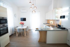 a kitchen with white cabinets and a table with a vase of flowers at Villa La Torre in San Giuliano Terme