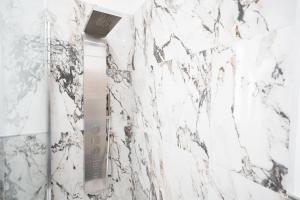 a bathroom with white marble walls and a mirror at Villa La Torre in San Giuliano Terme