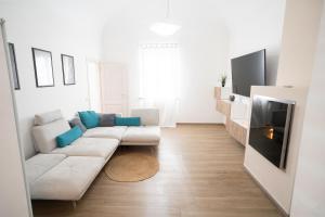 a living room with a white couch and a tv at Villa La Torre in San Giuliano Terme