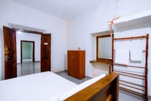 een slaapkamer met een bed en een spiegel bij Ramya Villa in Weligama