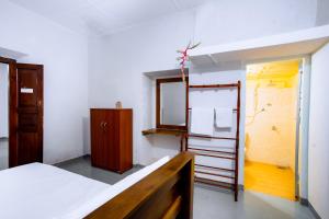een kamer met een bed, een spiegel en een ladder bij Ramya Villa in Weligama