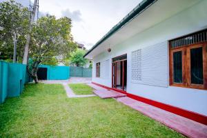 een wit huis met een tuin ernaast bij Ramya Villa in Weligama