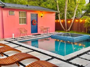a pink house with a swimming pool in the backyard at Salthaus West Palm Beach - NEW Saltwater Pool & Spa! in West Palm Beach