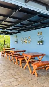 Una fila de mesas de picnic de madera en una habitación. en The Aradhya Villa, en Wayanad