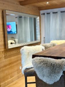 a dining room with a table and a mirror at Chalet Beaufort in Saint-Martin-de-Belleville