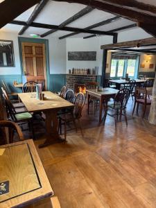 a dining room with tables and chairs and a fireplace at The Lord Raglan in Staplehurst