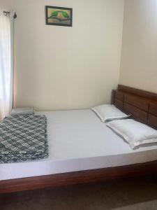 Hallibailu Cottage في Jāmb: غرفة نوم بسرير كبير مع ملاءات بيضاء
