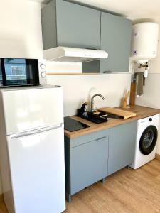 Grand Studio Cosy 39m2, Rénové & Climatisé في سان دوني: مطبخ مع ثلاجة بيضاء ومغسلة