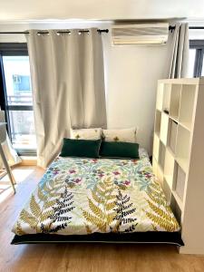 a bedroom with a bed with a colorful comforter at Grand Studio Lumineux & Rénové & Climatisé in Saint-Denis
