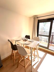 a dining room with a table and chairs and a window at Grand Studio Lumineux & Rénové & Climatisé in Saint-Denis