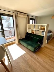 a room with a couch and a bed and a window at Grand Studio Lumineux & Rénové & Climatisé in Saint-Denis +8 photos
