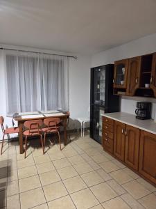 a kitchen with a table and some chairs and a table at Willa MARSI in Stalowa Wola +5 photos