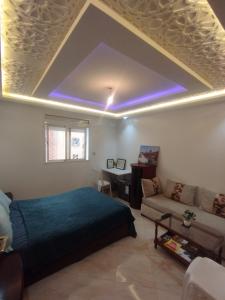 a bedroom with a bed and a couch at Appartement Sala Al Jadida in Oulad Yakoub