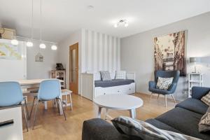 a living room with a couch and a table and chairs at Fewo Henri in Zempin