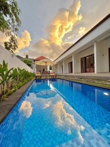 Amitha Lodge Uluwatu في Uluwatu: مسبح وبلاط ازرق امام المنزل