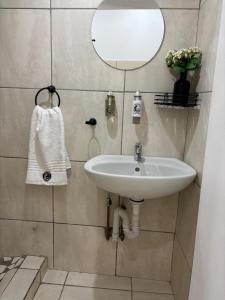a bathroom with a sink and a mirror at Seven on Cooper in East London