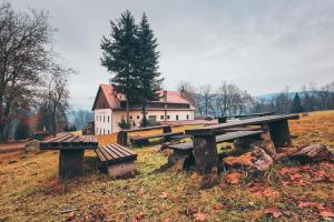 a picnic table and bench in front of a house at Chata Kačerov in Kašperské Hory