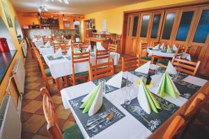 a restaurant with white tables and chairs with green napkins at Chata Kačerov in Kašperské Hory