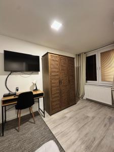 Zimmer mit einem Schreibtisch, einem TV und einem Computer in der Unterkunft VIP Apartments in Senica