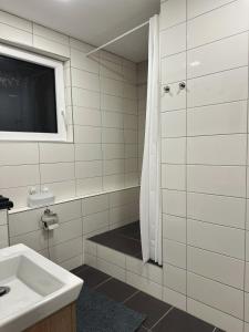 ein weißes Badezimmer mit Waschbecken und Dusche in der Unterkunft VIP Apartments in Senica
