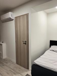 eine Holztür in einem Zimmer mit einem Bett in der Unterkunft VIP Apartments in Senica