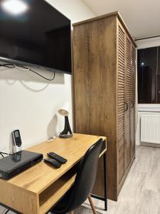 ein Holzschreibtisch mit einem Fernseher darauf in der Unterkunft VIP Apartments in Senica