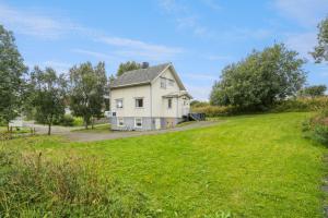 House in the middle of Lofoten - Leknes في ليكنيز: منزل على تلة مع حقل أخضر