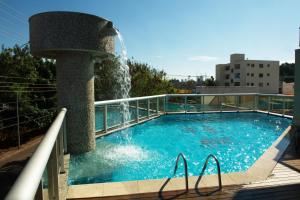 a swimming pool with a water fountain on a building at Hotel Metropolitan in Campo Grande